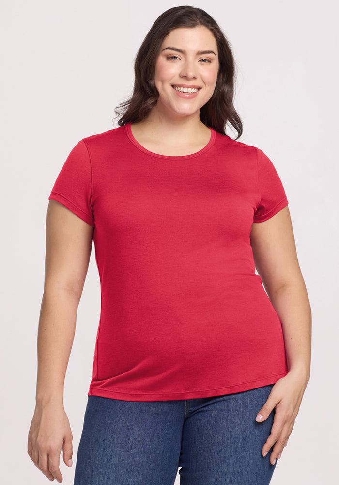 Woman smiles in a Woolx Addie Crew Neck - Berry Ice Pop Merino T-shirt and blue jeans against a plain background. | Juliana is 5'10", wearing a size XL