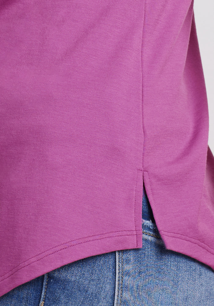 Close-up of Woolx Bella Tunic Top in Purple Wine, lightweight with side slit, styled over blue jeans.