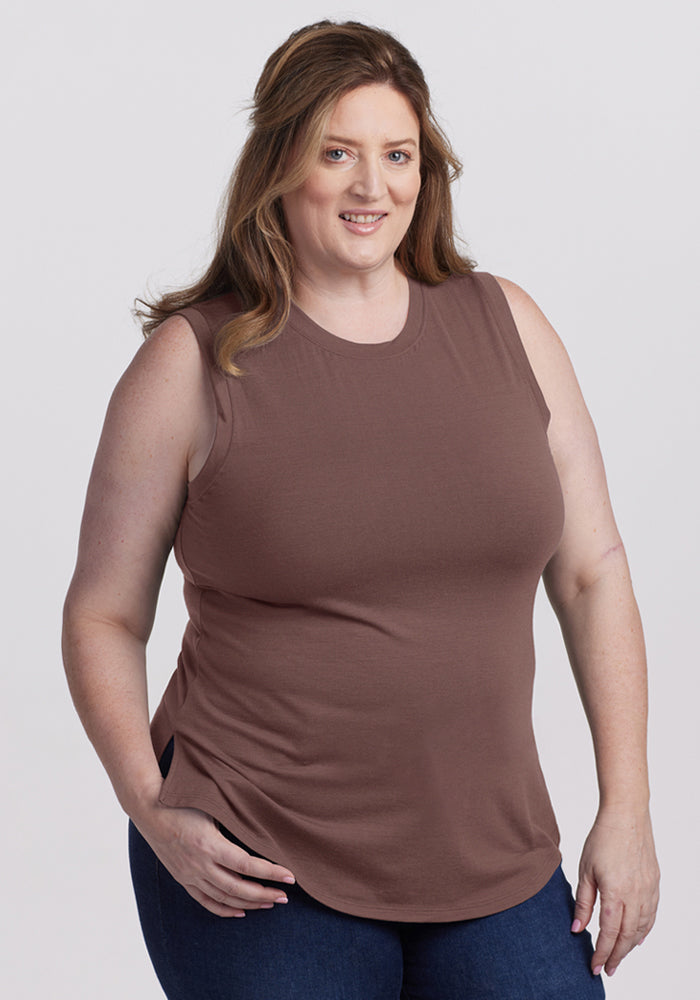 A woman in a Woolx Bella Tunic Top - Peppercorn and blue jeans smiles at the camera against a plain background. | Cambre is 5'11", wearing a size XL