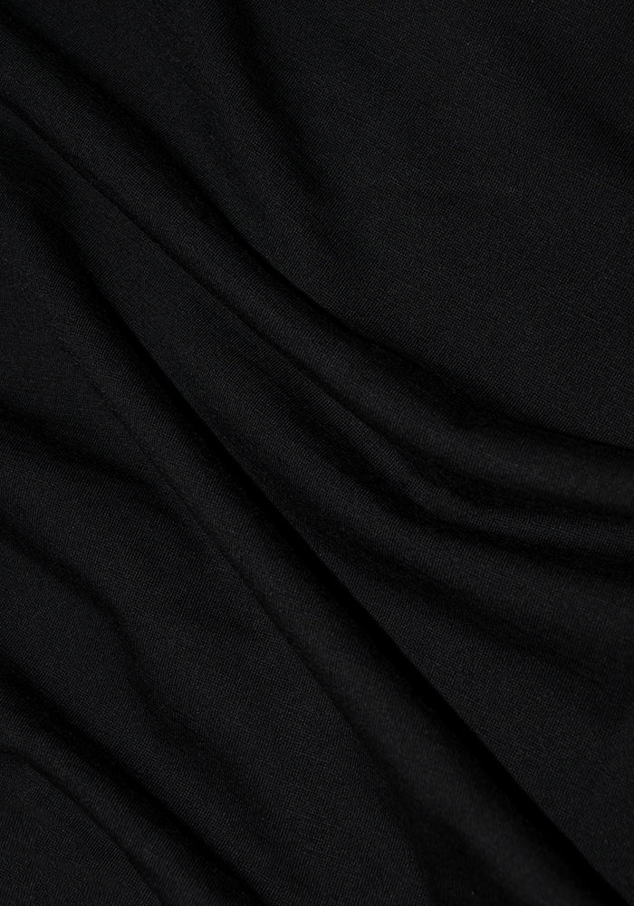 Close-up of the Woolx Bronx Henley in black, featuring gentle folds that highlight its Woolmark Certified smooth and soft texture.