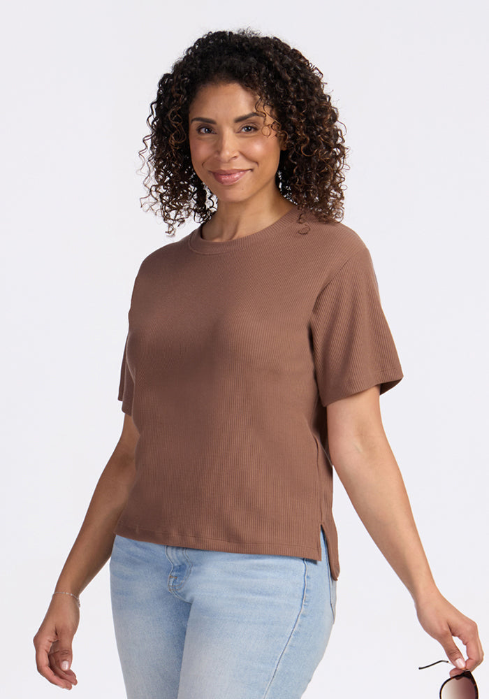 Woman with curly hair smiles in a Woolx Delia Ribbed Short Sleeve in Sienna Kiss and light blue jeans, on white.