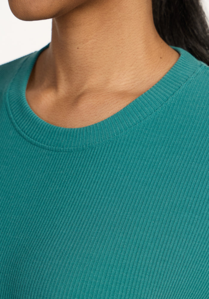 Close-up of a person wearing the Woolx Delia Ribbed Short Sleeve in Surfside, showing the neckline and shoulder.