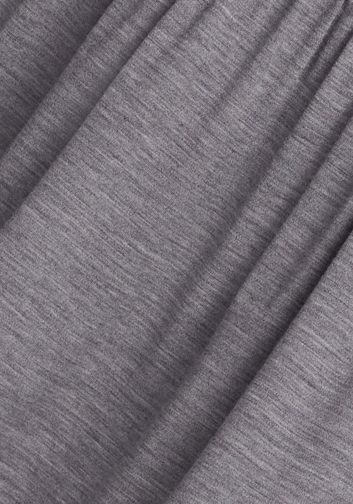 A close-up of the Georgie Dress - Graphite Heather by Woolx reveals its gray fabric with a soft, heathered texture. Ideal for temperature regulation, the dress's material includes subtle shade variations and gentle folds for a flowing appearance.