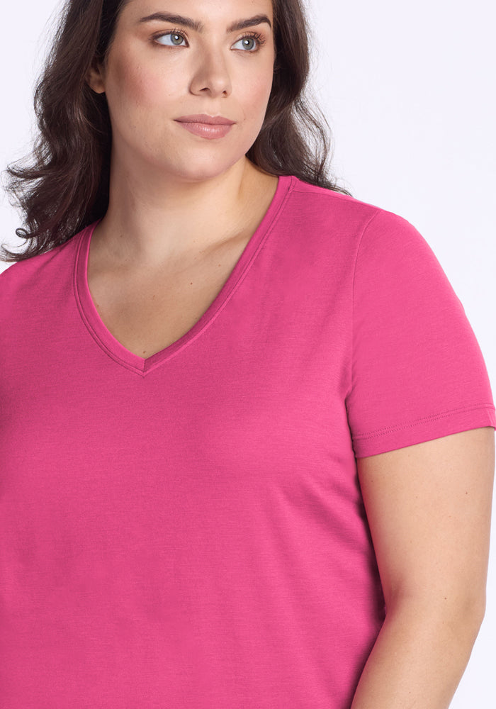 Woman wears the Woolx Junie V Neck in Raspberry Fizz, short-sleeve relaxed fit, against a light background.