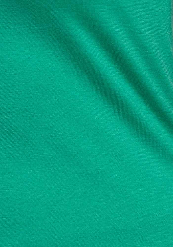 Close-up of Woolx Junie V Neck - Jungle, showing green merino wool fabric with fine, visible texture and light wrinkle.