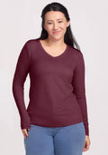 Woman in a Woolx Millie Long Sleeve (Grape Harvest), smiling in blue jeans against a light background.