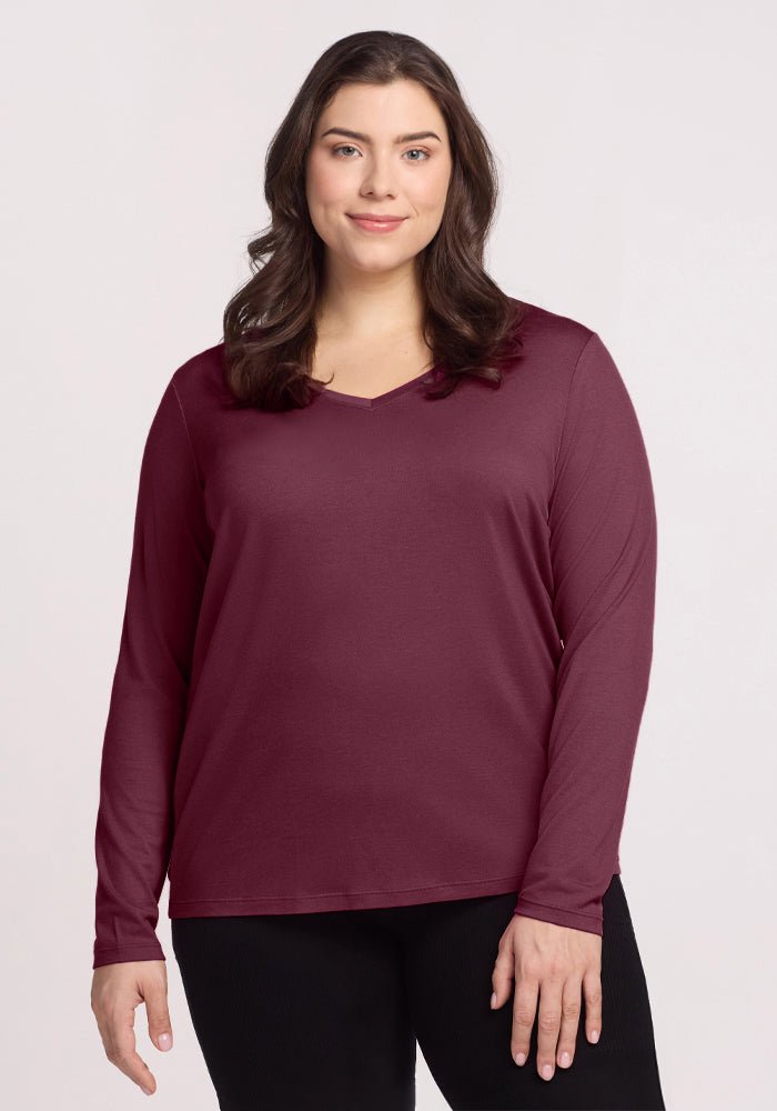 Woman wearing the Woolx Millie Long Sleeve in Grape Harvest and black pants, standing and smiling at the camera.