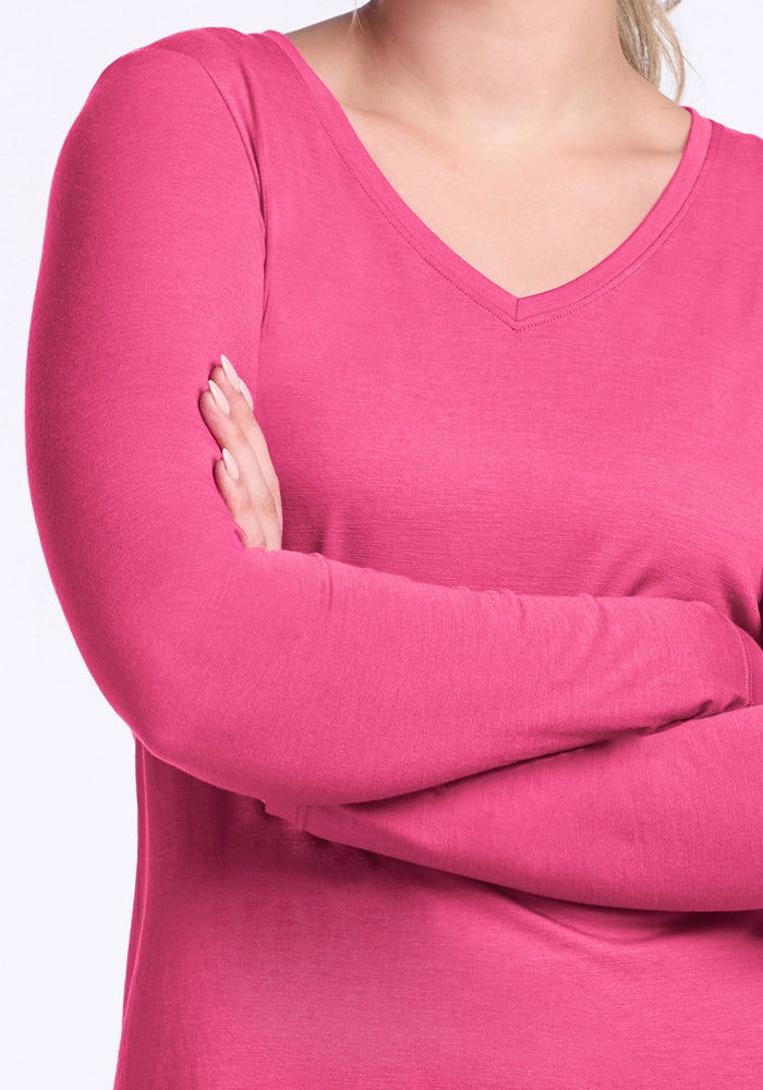 A person wears the Woolx Millie Long Sleeve in Raspberry Fizz, arms crossed, shown shoulder to waist.
