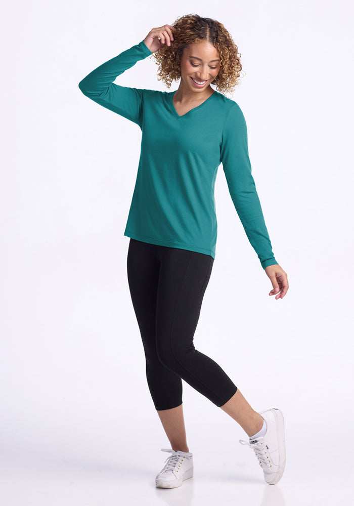 Woman in a Woolx Millie Long Sleeve - Surfside, black leggings, and white sneakers posing against a white background.