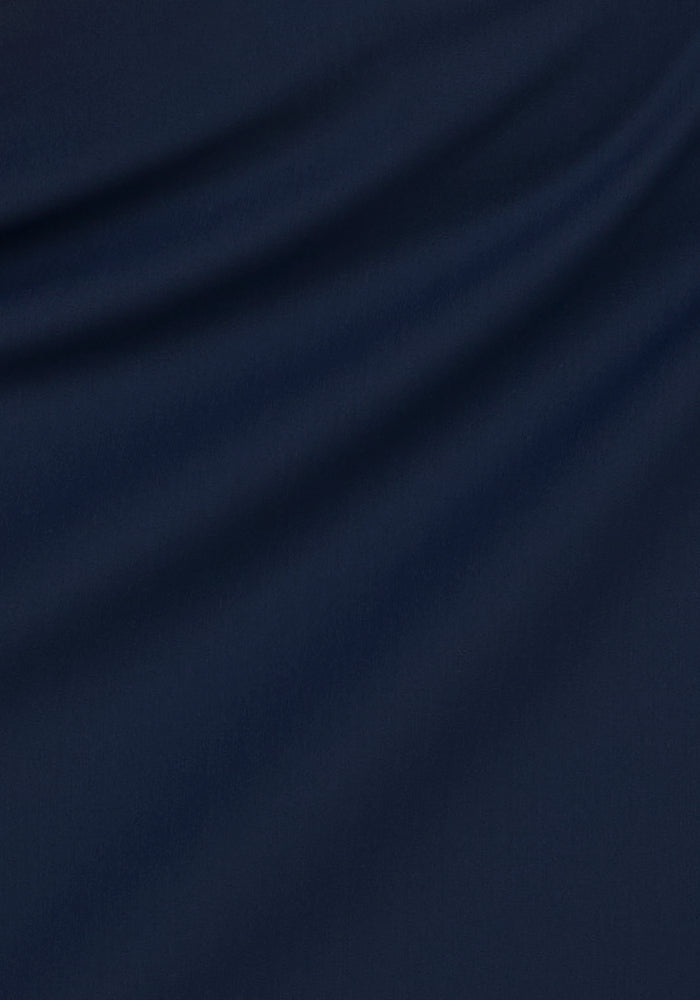 The Woolx Nicole Petite Ankle Pant in Deep Navy features soft fabric with gentle, diagonal folds that create smooth shadows and a flowing, elegant drape—ideal for crafting stylish, lightweight petite pants.