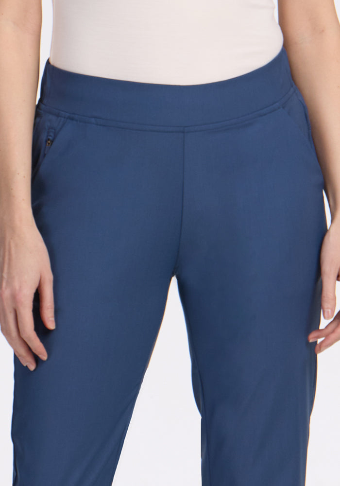 A person wearing Woolx's Nicole Petite Ankle Pant in Vintage Indigo and a white top, shown from mid-torso to thighs, with arms relaxed at their sides.
