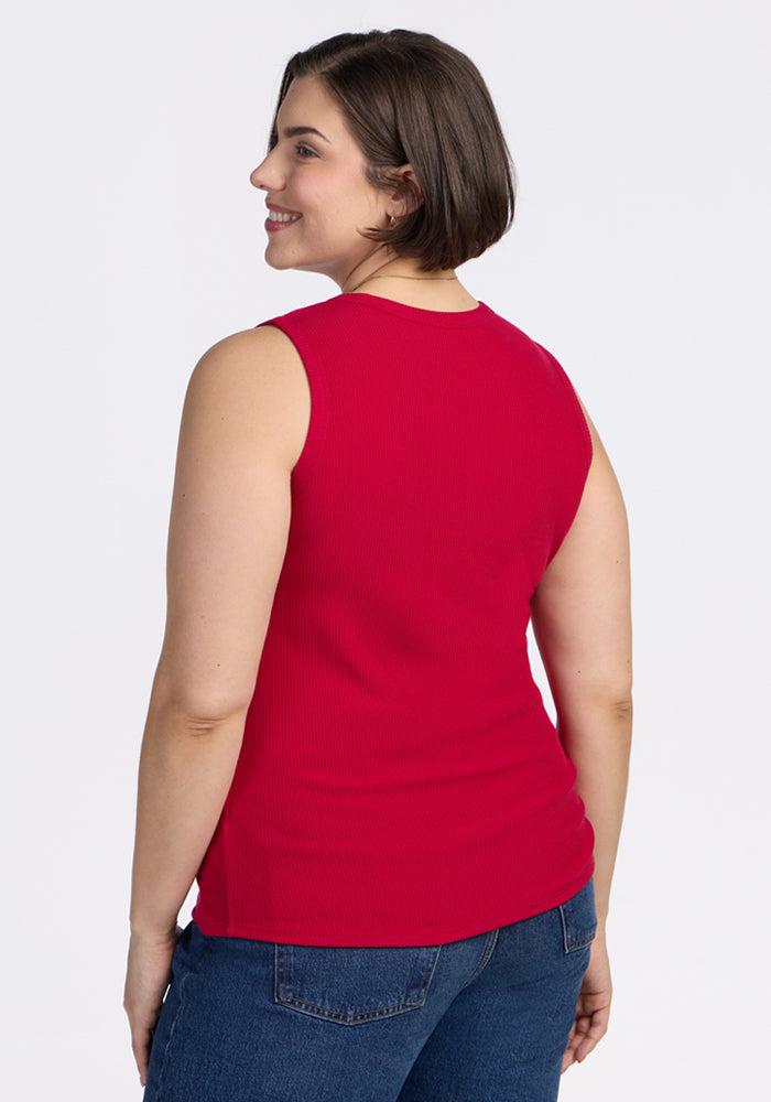 A woman with short brown hair, shown from the back smiling, wears the Woolx Raegan Ribbed Tank Top in Poppy Spark and blue jeans.