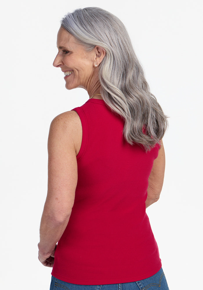 Smiling woman with long gray hair wears the Woolx Raegan Ribbed Tank Top in Poppy Spark, seen from behind.