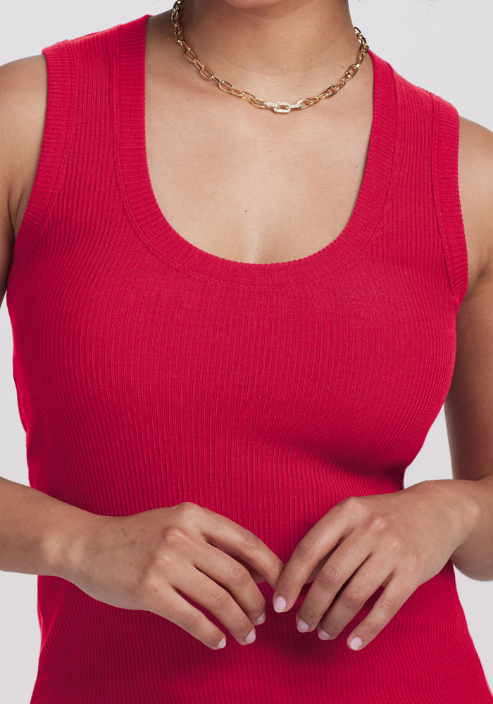 Woman wearing the Woolx Sloane Ribbed Tank in Poppy Spark, hands together at her waist. Final Sale item.