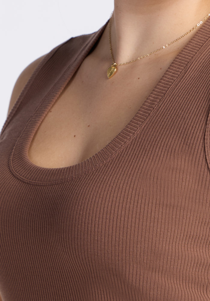 Close-up of a person wearing the Woolx Sloane Ribbed Tank in Sienna Kiss and a gold heart pendant necklace.