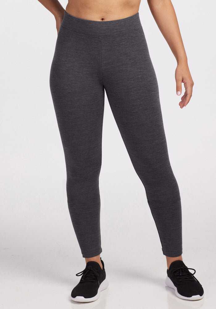 A person wearing Woolx Stella Leggings in Cinder Melange stands against a plain white background. Only their lower body, from the chest down, is visible. | Tori is 5'7", wearing a size S