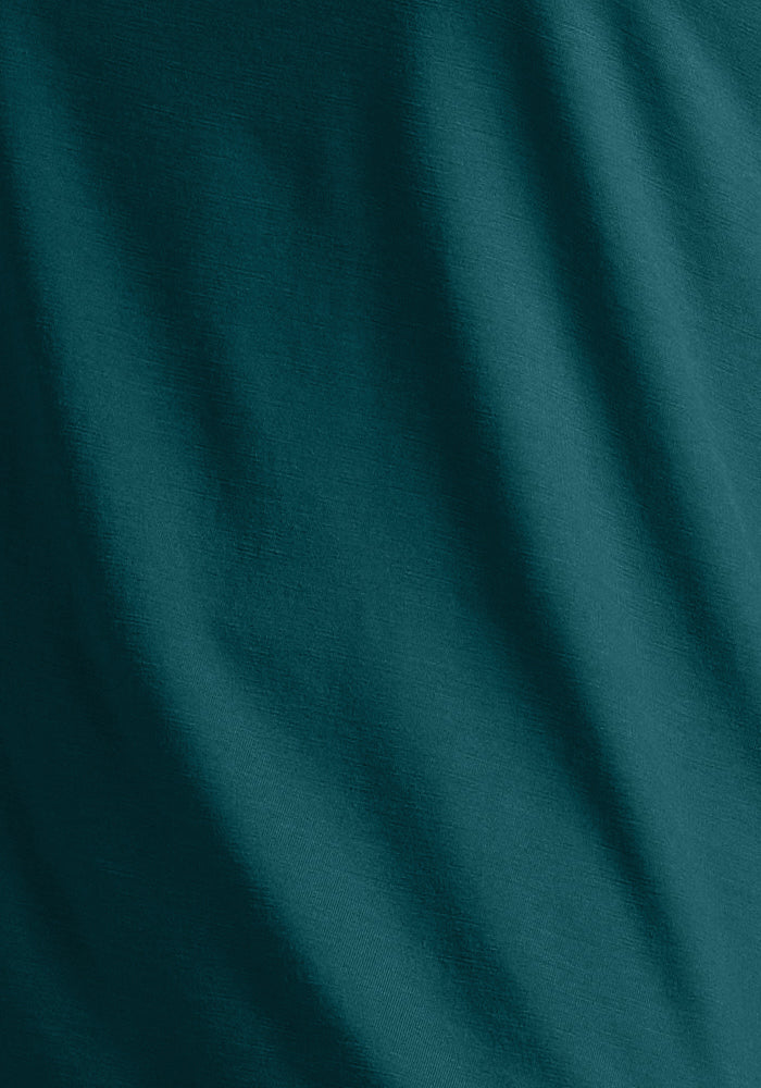 The Woolx Summit Polo in Riverbank Green features soft merino wool with gentle diagonal folds and a textured finish.