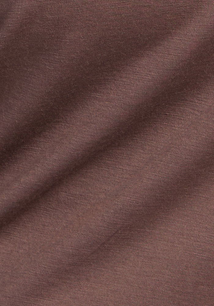 Close-up of Woolx Summit Polo - Peppercorn, showing fine-textured brown fabric with soft, diagonal folds.