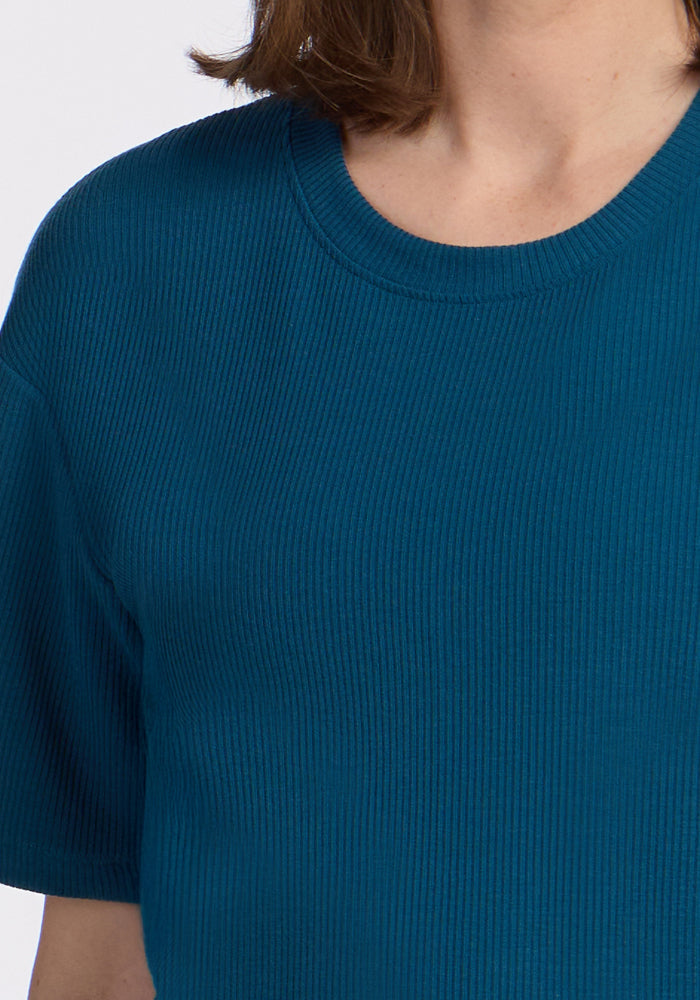 Person wearing the Woolx Vera Ribbed Tunic in Moroccan Blue, shown from neck to mid-torso. Final Sale.