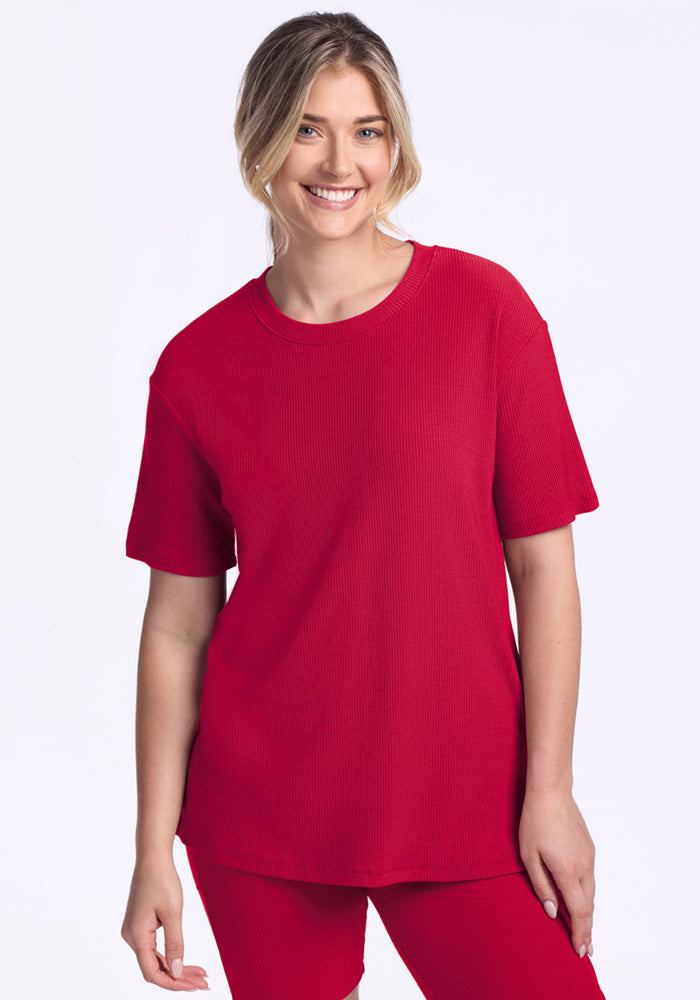 Smiling woman in Woolx Vera Ribbed Tunic • Final Sale - Poppy Spark, relaxed fit, against a plain white background.