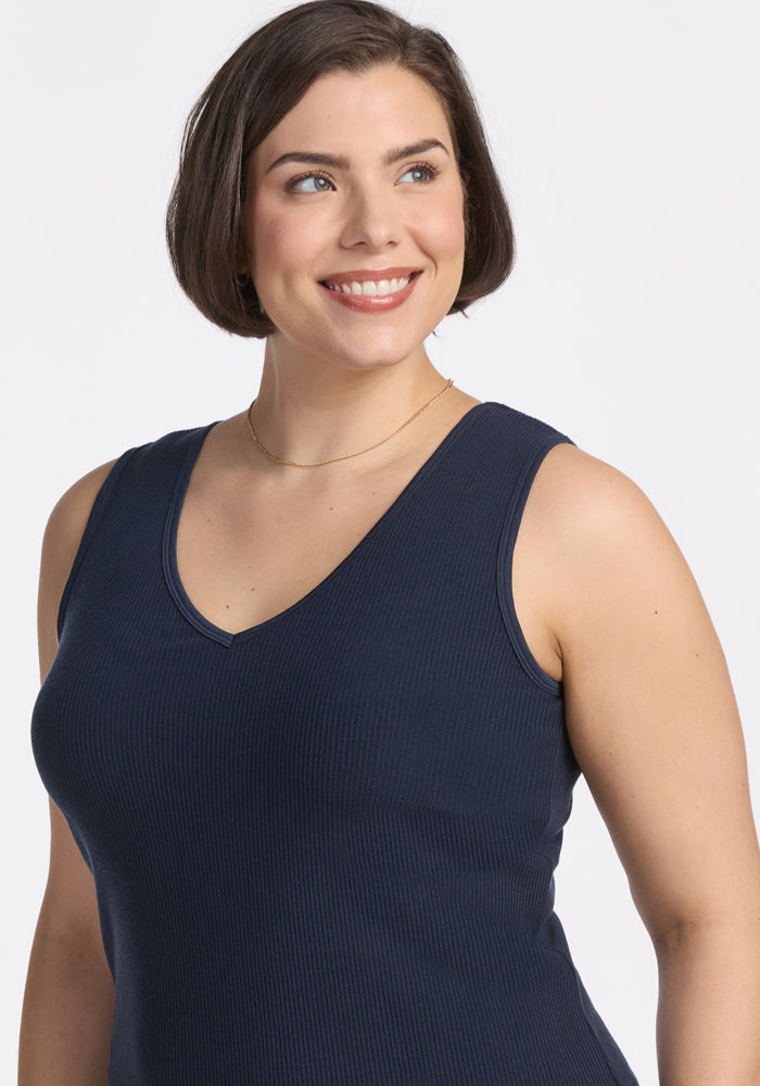 Smiling woman in the Woolx Vivi Ribbed Tank • Final Sale - Deep Navy, accessorized with a thin gold necklace.
