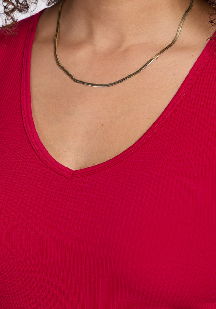 A person wearing the Woolx Vivi Ribbed Tank in Poppy Spark and a thin gold necklace.