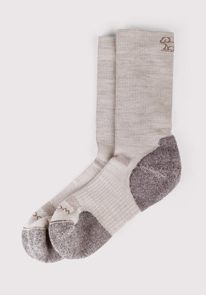 The Woolx Womens Harbor Crew Sock - Icicle is a light beige Merino wool crew sock with reinforced gray heels and toes, lightweight cushioning, and a small embroidered logo near the top, shown laid flat on a white background.