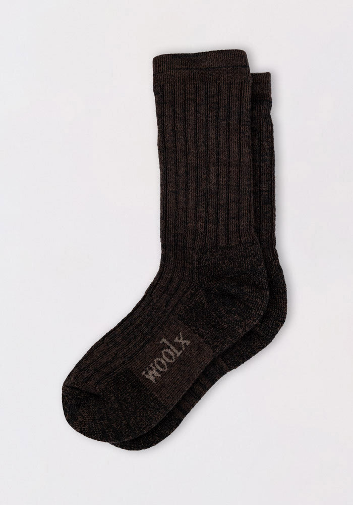 A pair of Womens Joey Crew Socks by Woolx in Dark Espresso, featuring ribbed merino wool and "wool" printed on the sole, shown on a plain light background.